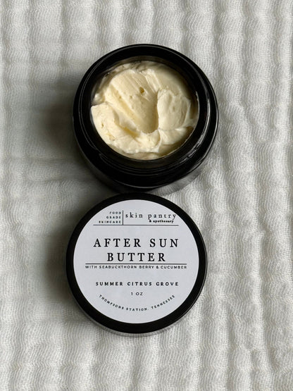Open jar of after sun butter with a label on a textured white background