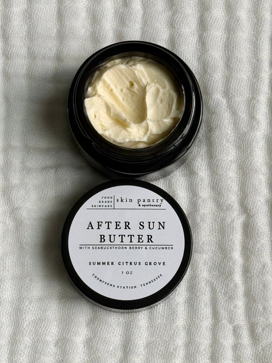 Open jar of after sun butter with a label on a textured white background